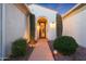 Well-lit entryway with arched doorway and landscaping at 13520 W Junipero Dr, Sun City West, AZ 85375