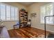 Bright home office with hardwood floors, built-in shelving, and comfortable seating at 2554 E Honeysuckle Pl, Chandler, AZ 85286