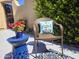Inviting outdoor seating area with a cozy chair, blue accent table, and vibrant potted flowers at 41716 N Laurel Valley Way, Anthem, AZ 85086