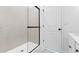 Modern bathroom with marble-look shower and black framed glass door at 7637 W Minton St, Laveen, AZ 85339