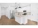 Bright kitchen features white cabinets, stainless steel appliances, a kitchen island, and light wood flooring at 7637 W Minton St, Laveen, AZ 85339