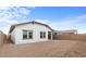 Exterior backyard view with white stucco walls, small covered patio, and block wall at 7641 W Minton St, Laveen, AZ 85339
