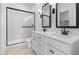 Modern bathroom with a glass shower, double vanity, and sleek black fixtures at 7641 W Minton St, Laveen, AZ 85339