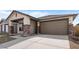 Beautiful new home with stone accents on the pillars and a wide driveway leading to a two car garage at 7641 W Minton St, Laveen, AZ 85339