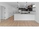 Modern kitchen with dark cabinets, stainless steel appliances, a white island and wood flooring throughout at 7641 W Minton St, Laveen, AZ 85339