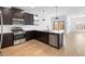 Open kitchen design featuring stainless steel appliances, dark cabinets, an island and a view of an adjacent dining area at 7641 W Minton St, Laveen, AZ 85339