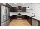 Spacious kitchen showcasing dark cabinetry, stainless steel appliances, a subway tile backsplash and wood flooring at 7641 W Minton St, Laveen, AZ 85339