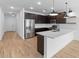 Modern kitchen featuring stainless steel appliances, dark cabinets, a large island and white subway tile backsplash at 7641 W Minton St, Laveen, AZ 85339