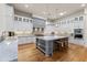 Bright kitchen with white cabinets, stainless appliances, marble countertops, a central island, and hardwood floors at 11885 N Sunset Vista Dr, Fountain Hills, AZ 85268