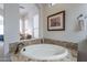 Bathroom with granite vanity, soaking tub, and tile accents at 1351 E Artemis Trl, Queen Creek, AZ 85140