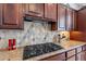 Gas cooktop and diamond patterned backsplash in kitchen at 1351 E Artemis Trl, Queen Creek, AZ 85140