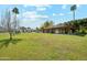 Sprawling backyard with lush lawn, covered patio, mature trees, and a picturesque view of the expansive property at 1440 E Secretariat Dr, Tempe, AZ 85284