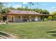 Expansive backyard featuring a covered patio with a swing and a lush lawn surrounded by trees, offering a relaxing outdoor space at 1440 E Secretariat Dr, Tempe, AZ 85284