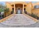 Close up of the grand entryway of the home with stone accents, pillars and steps to the black iron door at 16149 E Thistle Dr, Fountain Hills, AZ 85268