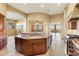 Open concept kitchen with granite countertops, wood cabinetry, and an island with sink and seating at 16149 E Thistle Dr, Fountain Hills, AZ 85268