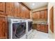 Well-organized laundry room with cabinetry, counter space, tile flooring, and appliances at 16149 E Thistle Dr, Fountain Hills, AZ 85268