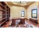 Bright home office featuring built-in bookshelves, desk, and natural light from two large windows at 16149 E Thistle Dr, Fountain Hills, AZ 85268