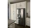 Stainless steel refrigerator in a kitchen with white cabinets and granite countertops at 1669 S Wallrade Ln, Gilbert, AZ 85295