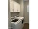 Laundry room with white washer and dryer, and overhead cabinets at 1669 S Wallrade Ln, Gilbert, AZ 85295