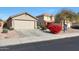 Front view of the house, showing the garage and red flowers at 22814 W Cantilever St, Buckeye, AZ 85326