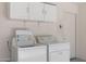 White washer and dryer set in garage with overhead cabinets at 22814 W Cantilever St, Buckeye, AZ 85326