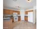 Kitchen with wood cabinets, white appliances, and tile floor at 22814 W Cantilever St, Buckeye, AZ 85326