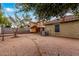 Large backyard with brick pavers, covered patio, and mature trees at 2440 W Bloch Rd, Phoenix, AZ 85041