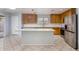 Kitchen features an island, stainless steel appliances, and light wood cabinets at 2440 W Bloch Rd, Phoenix, AZ 85041