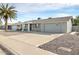 Gray single story home with a two car garage and palm trees in front at 10436 N Balboa Dr, Sun City, AZ 85351