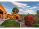 Landscaped backyard with a grassy area, flowering bushes, and a mountain view at 11157 E Greenway Rd, Scottsdale, AZ 85255