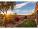 Landscaped backyard with a grassy area, trees, and mountain views at 11157 E Greenway Rd, Scottsdale, AZ 85255