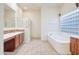 Elegant bathroom with soaking tub, shower, and dual vanity at 11157 E Greenway Rd, Scottsdale, AZ 85255