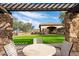 Seating area with pergola offering views of the BBQ area and lawn at 11157 E Greenway Rd, Scottsdale, AZ 85255