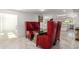 Dining area with red high back chairs and glass top table at 15810 N Nicklaus N Ln, Sun City, AZ 85351