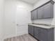 Laundry room with gray cabinets and granite countertops at 2917 N Katie Ln, Litchfield Park, AZ 85340