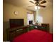 Bedroom with a red bedspread, TV, and workspace at 44920 W Miraflores St, Maricopa, AZ 85139