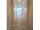 Well-lit hallway with tile flooring leading to the open living space and rear yard views at 4866 N 185Th Dr, Goodyear, AZ 85395