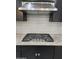 Close-up of a stainless steel gas cooktop and modern range hood in a stylish kitchen at 4866 N 185Th Dr, Goodyear, AZ 85395
