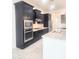Modern kitchen showcasing granite counters, gas cooktop, stainless appliances, and stylish dark cabinetry at 4866 N 185Th Dr, Goodyear, AZ 85395