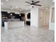 Bright, open kitchen and living room with a spacious island, stylish lighting, and tiled floors at 4866 N 185Th Dr, Goodyear, AZ 85395