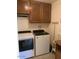 Convenient laundry room featuring modern washer and dryer units with overhead cabinets at 7950 E Keats Ave # 194, Mesa, AZ 85209