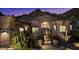 Elegant desert home featuring a beautifully landscaped front yard with a wrought iron gate and desert foliage at 11132 E Juan Tabo Rd, Scottsdale, AZ 85255