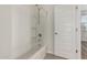 Bright bathroom featuring a shower-tub combo and a crisp white door at 2578 N Acacia Way, Buckeye, AZ 85396