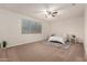 Inviting bedroom with ceiling fan, plush carpet, and natural light from a window at 2578 N Acacia Way, Buckeye, AZ 85396