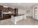 Modern kitchen featuring dark wood cabinets, granite countertops, stainless steel appliances and a center island at 2578 N Acacia Way, Buckeye, AZ 85396