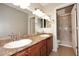 Bathroom featuring double vanity, modern mirrors, and a glass door shower at 5122 E Shea Blvd # 1117, Scottsdale, AZ 85254