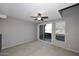 Carpeted bedroom featuring a ceiling fan, sliding glass door and windows at 5122 E Shea Blvd # 1117, Scottsdale, AZ 85254