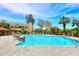 Beautiful community pool with lounge chairs, lush landscaping, and a clear blue sky at 5122 E Shea Blvd # 1117, Scottsdale, AZ 85254