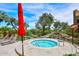 Inviting hot tub with a red umbrella, landscaped surroundings, and comfortable lounge chairs at 5122 E Shea Blvd # 1117, Scottsdale, AZ 85254