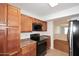 Functional kitchen with wooden cabinetry, black appliances, and ample counter space for preparing meals at 5122 E Shea Blvd # 1117, Scottsdale, AZ 85254